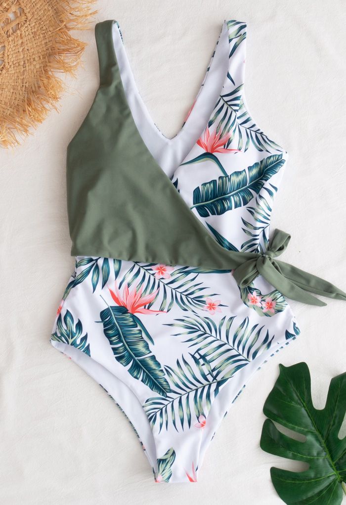 Wickeln Sie einen einteiligen Badeanzug mit tropischen Blättern an der Vorderseite
