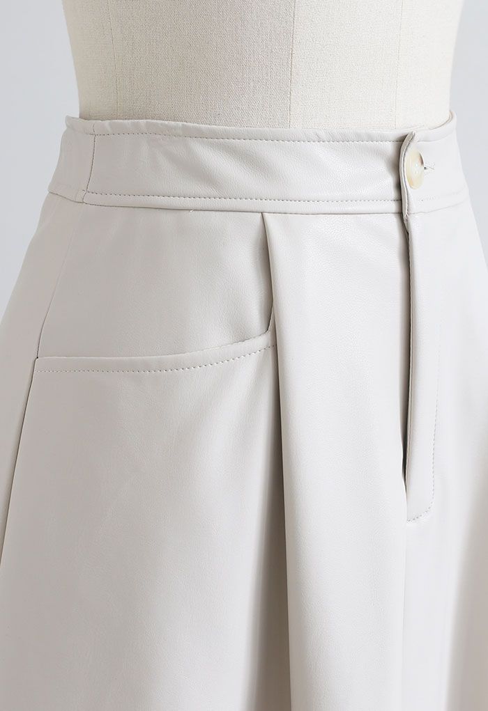 A-Linienrock aus Kunstleder mit zwei aufgesetzten Taschen in Elfenbein