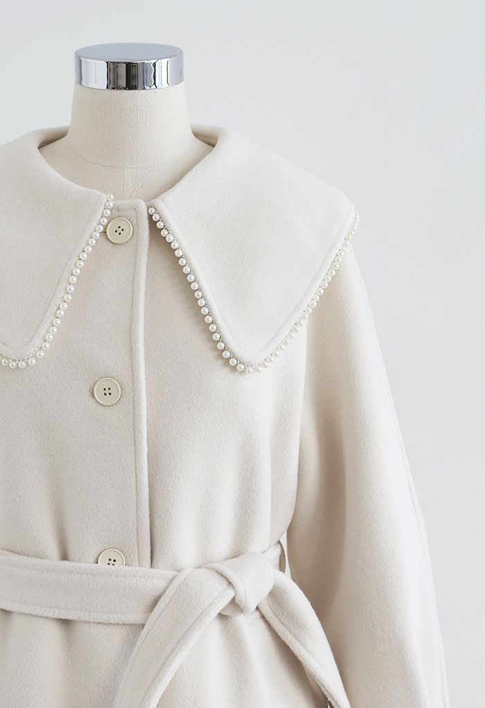 Lang geschnittener Mantel aus einer Wollmischung mit Perlenkanten in Creme