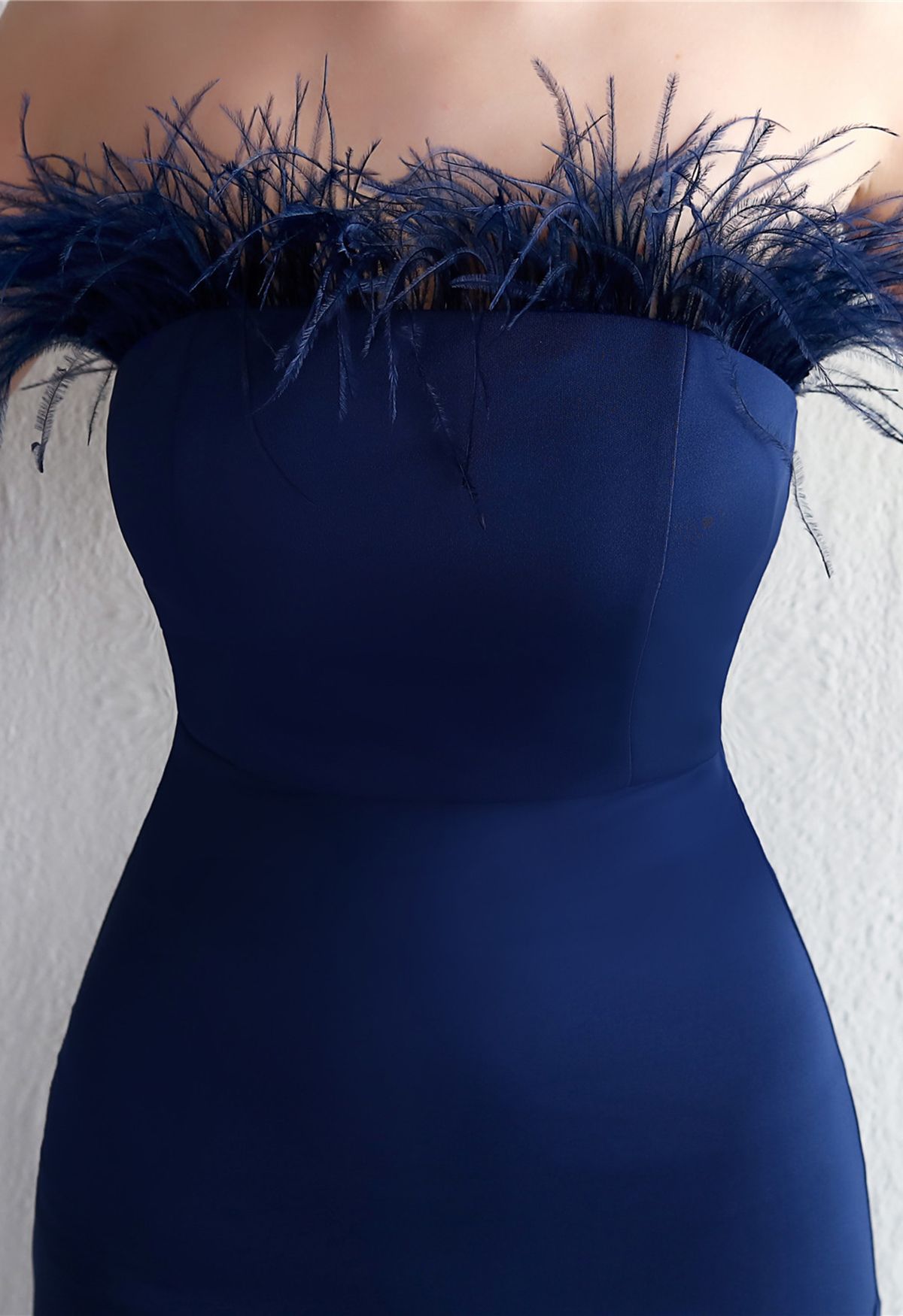 Trägerloses, geschlitztes Kleid mit Federbesatz in Marineblau