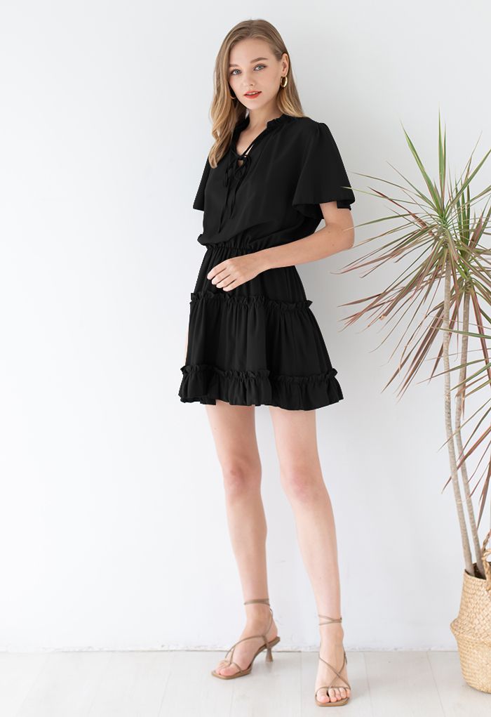 Kleid mit V-Ausschnitt und ausgestellten Ärmeln und Rüschenbesatz in Schwarz