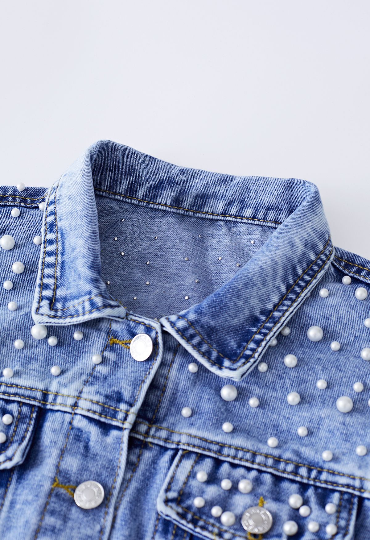 Perlverzierte Jeansjacke mit Pattentaschen in Blau