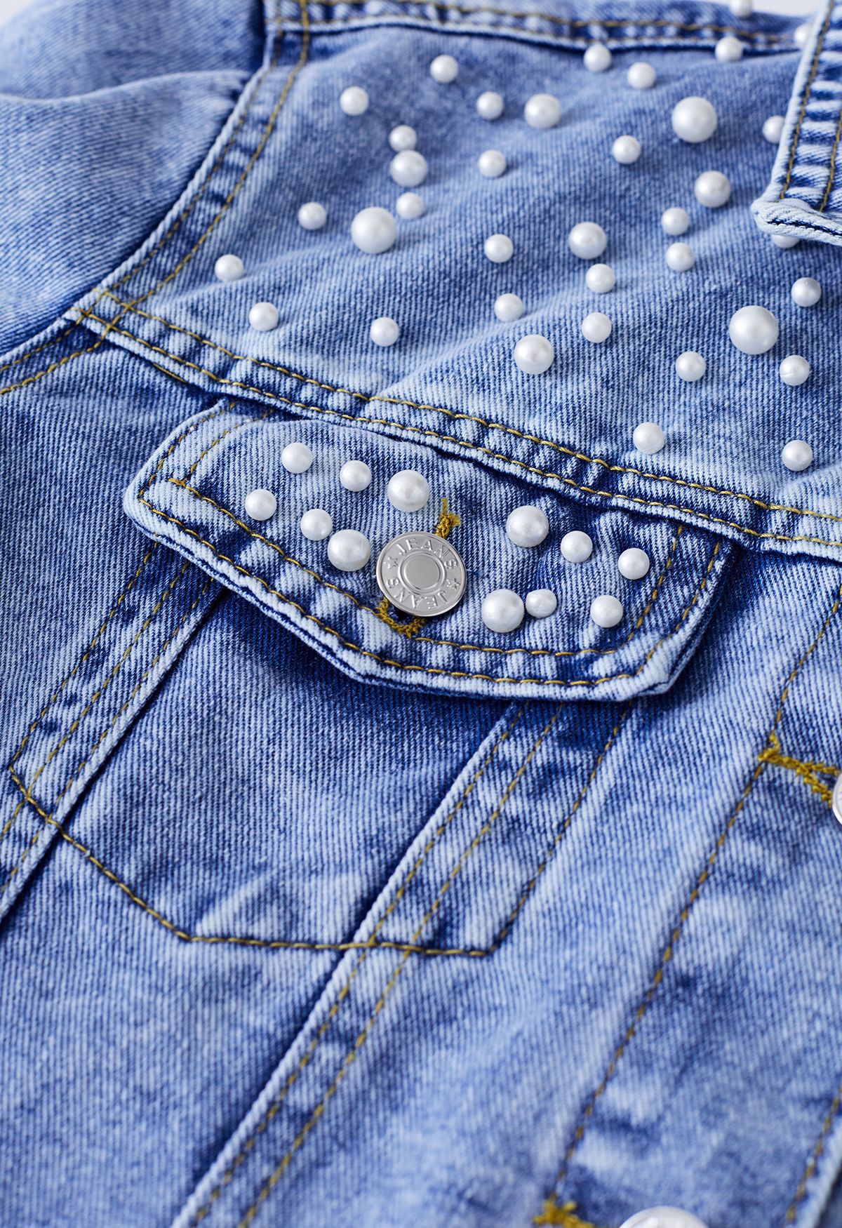 Perlverzierte Jeansjacke mit Pattentaschen in Blau