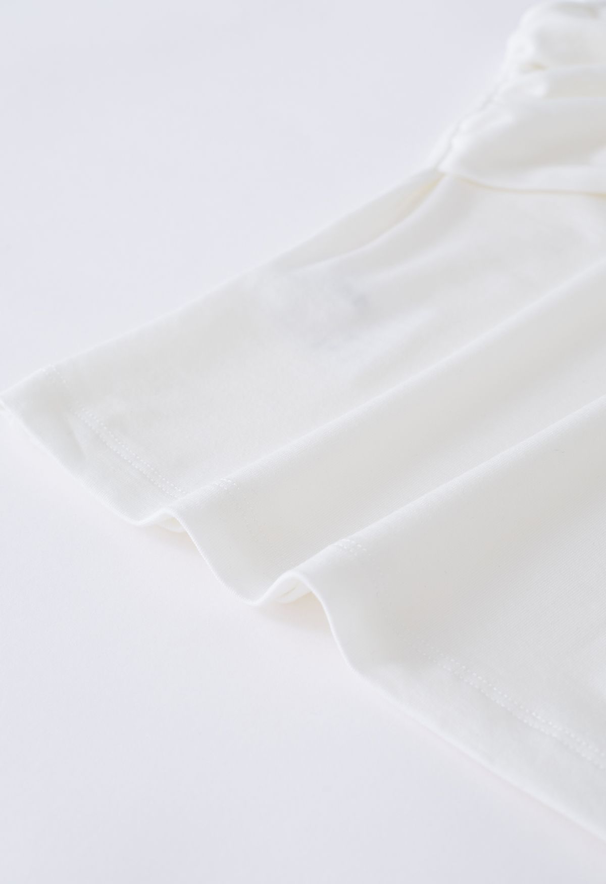 Schulterfreies, figurbetontes Crop-Top mit verdrehter Vorderseite in Weiß