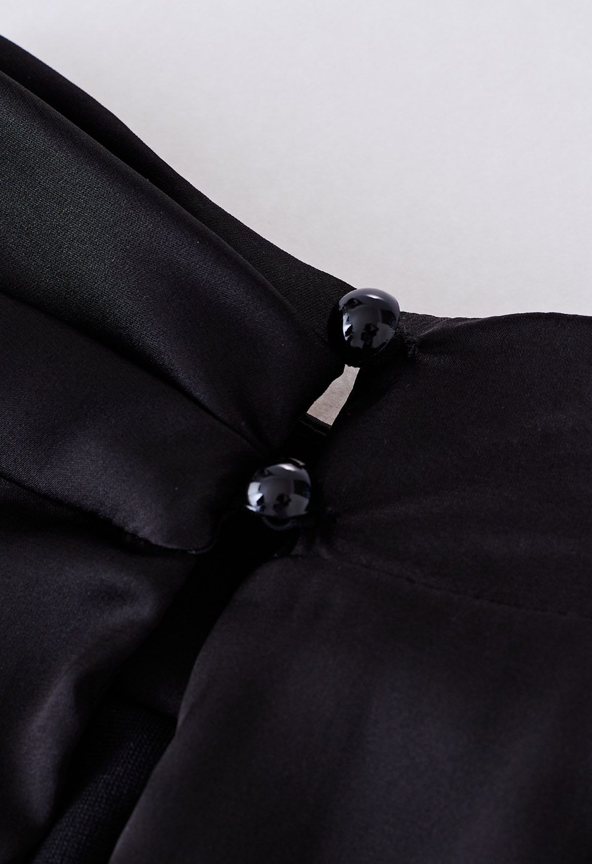 Ärmelloser Playsuit aus Satin mit asymmetrischem Rüschenausschnitt in Schwarz