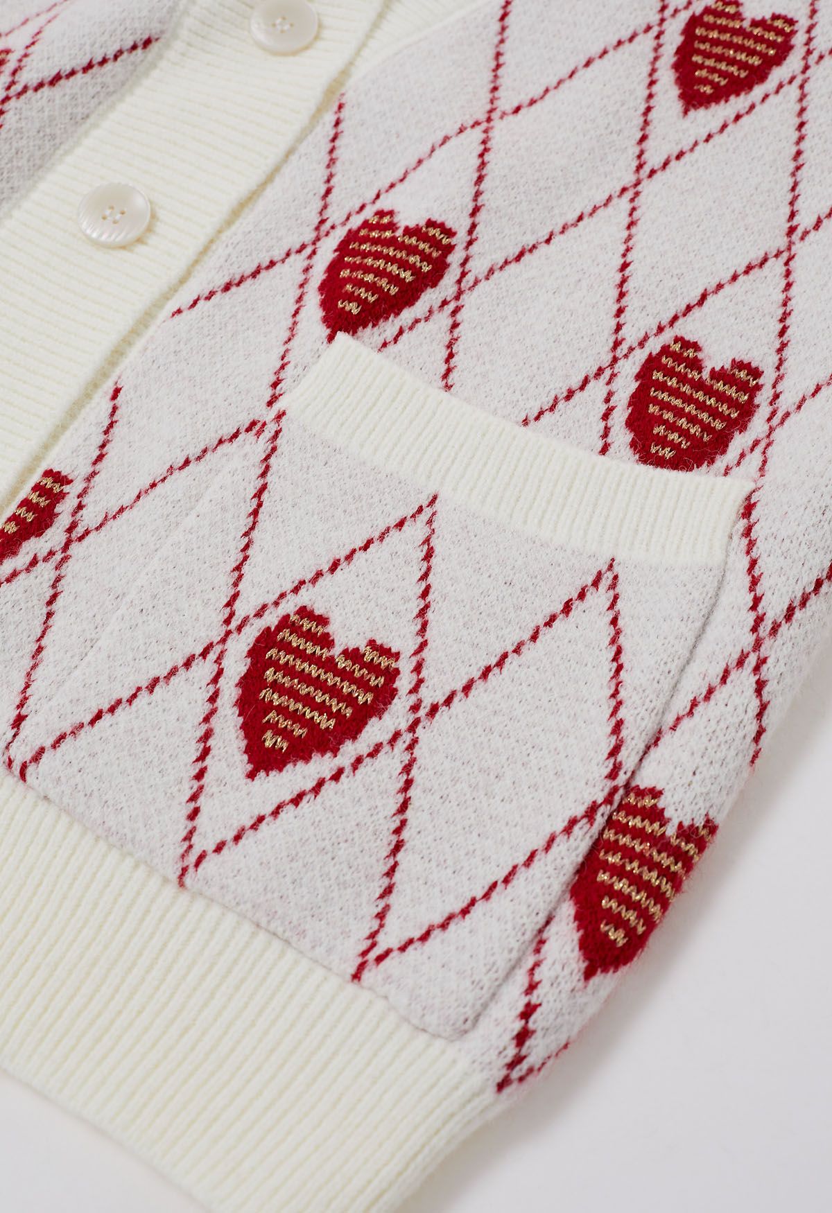 Strickjacke mit rautenförmigem Herzmuster und Knöpfen in Weiß