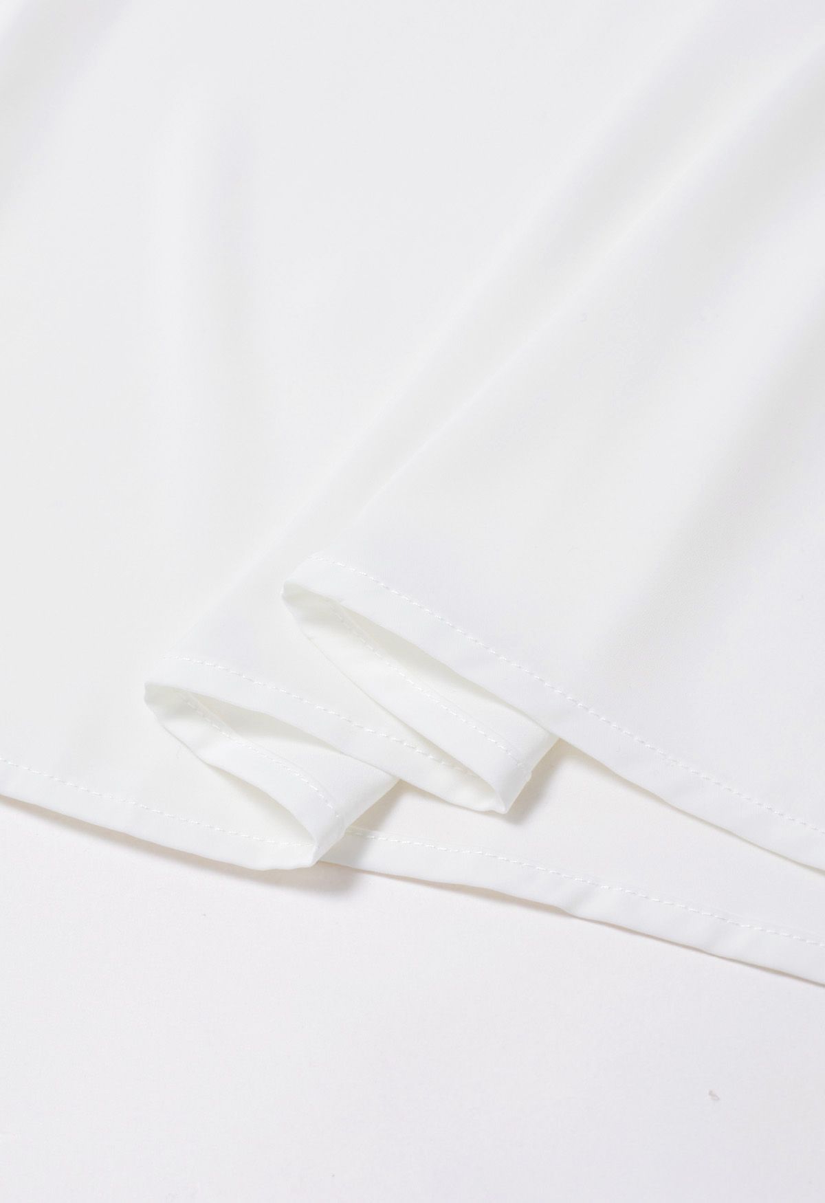 Gespleißtes Oberteil aus glänzendem Organza mit Perlmuttschleife in Weiß