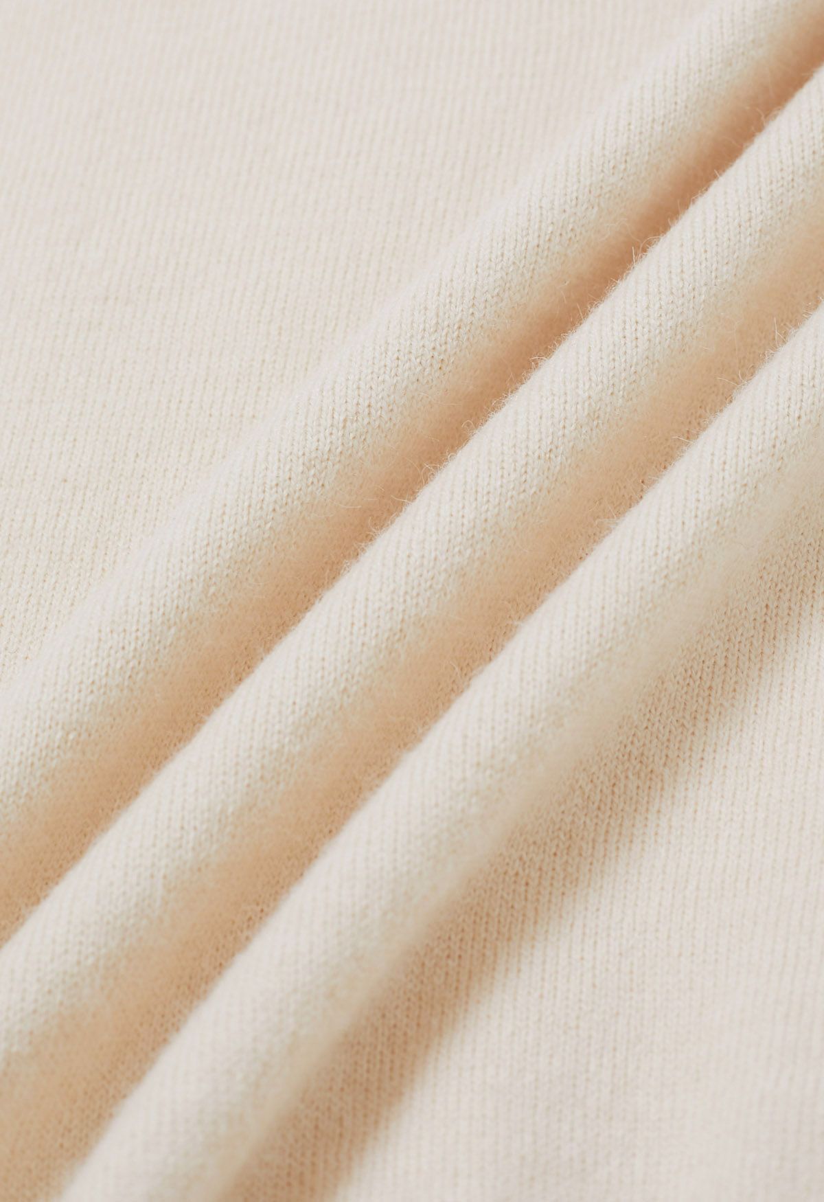 Set aus ärmellosem Strickoberteil und Faltenrock mit V-Ausschnitt in Creme