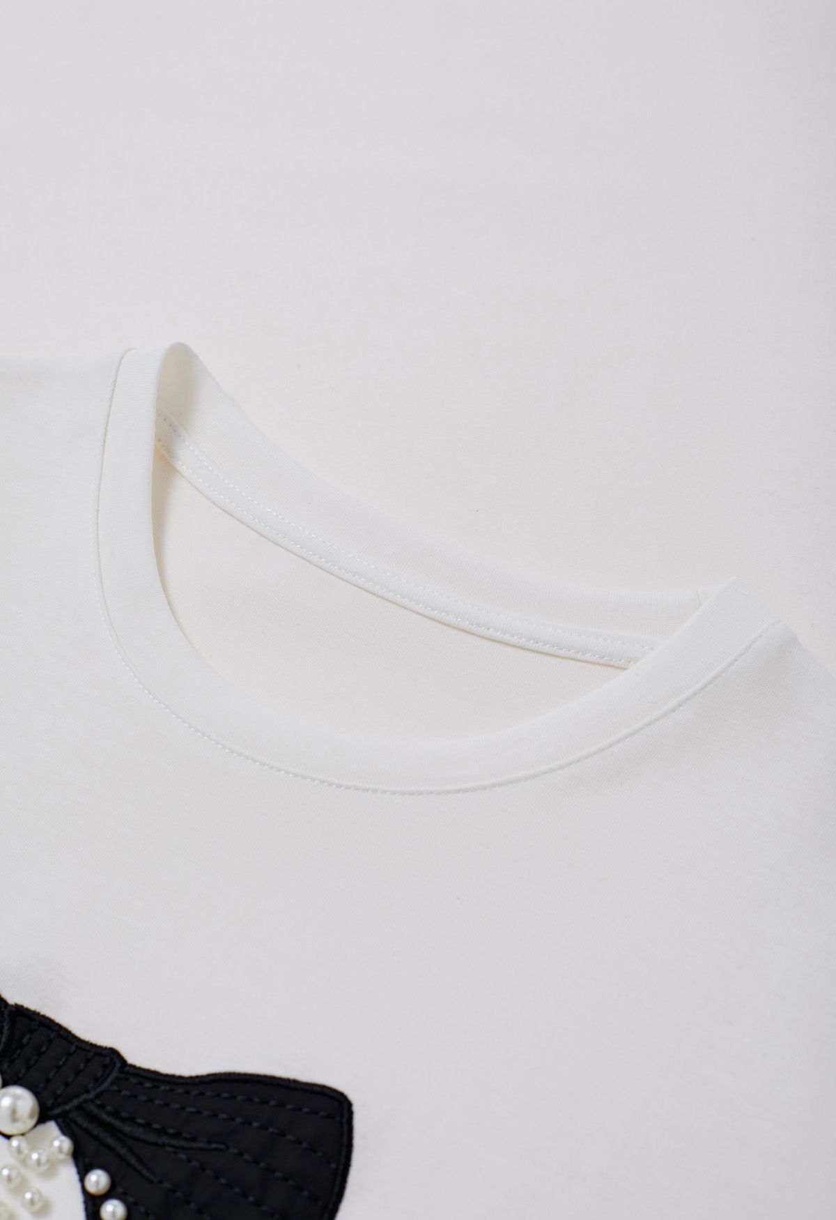 Weißes T-Shirt mit Schleifenmuster und Perlenverzierung