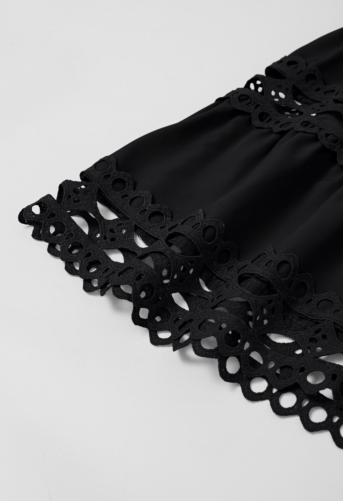 Schwarzes Midikleid mit Cutwork-Spitzenbesatz und Puffärmeln