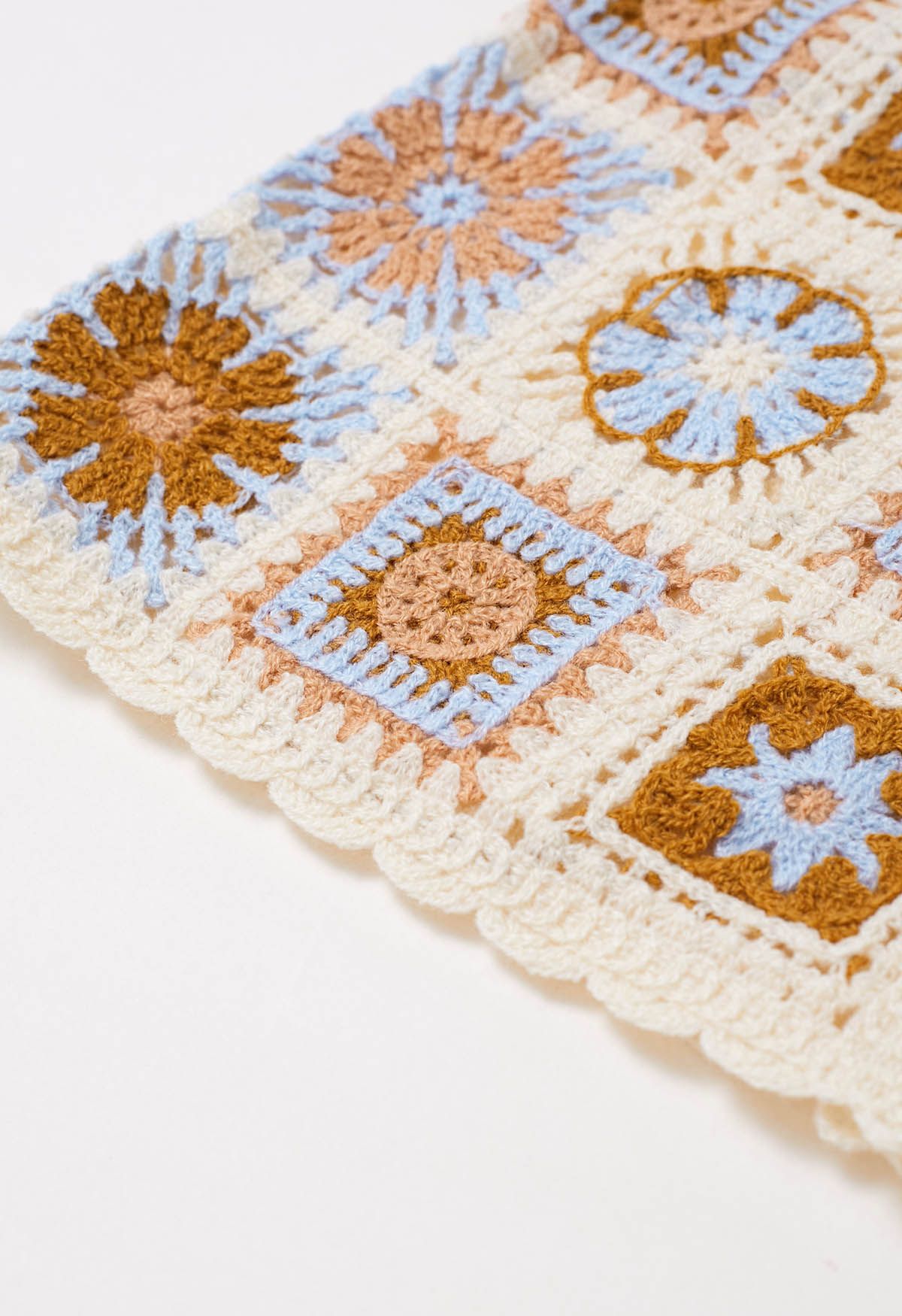 Gehäkelte Strickweste mit Blumen-Patchwork und Knöpfen