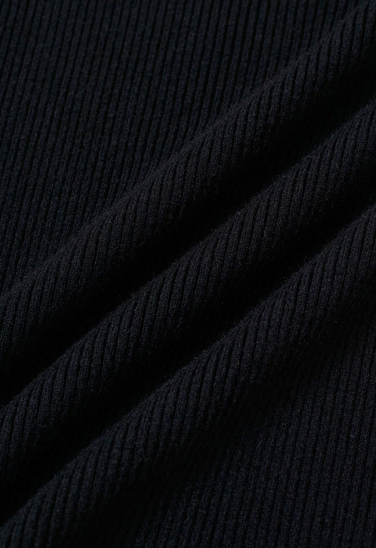 Geripptes Strickoberteil mit Herzknopf und Schleife in Schwarz