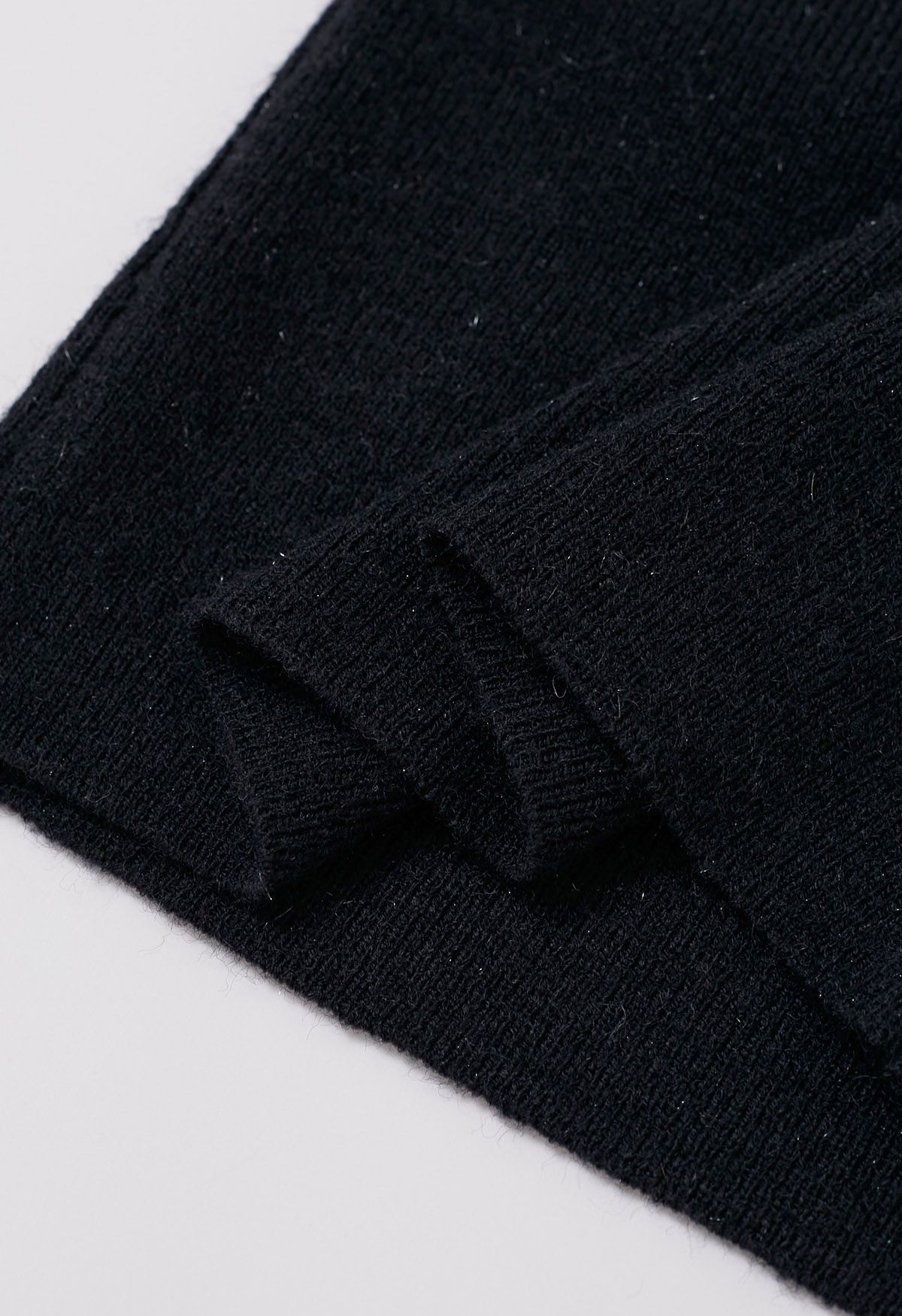 Zierliches Stricktop mit Spitzenmanschetten und Schleife in Schwarz